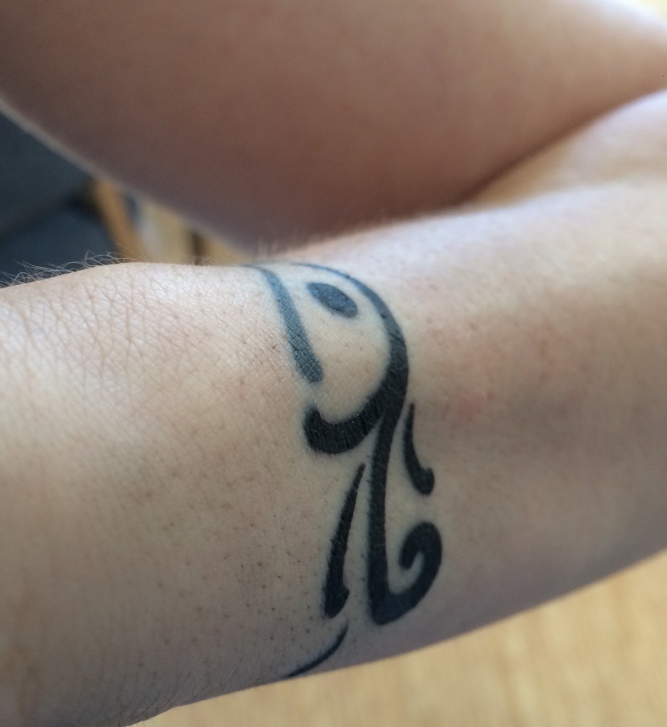 The dark ink is the new tattoo, adding onto the line of the old piece, which you can see to the top left.